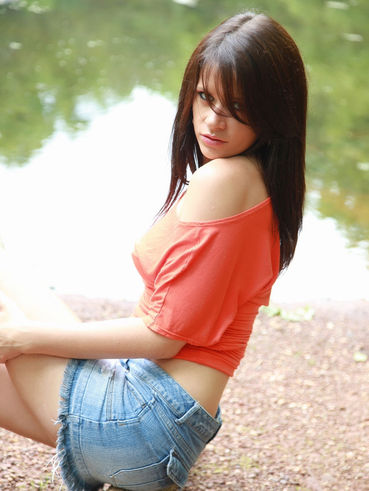 Sweet Ann Angel In Blue Jean Mini Skirt And Red T-Shirt Spreads Poses On The Bank Of The River